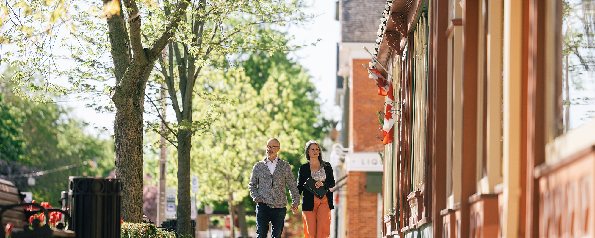 An older couple walking down the side walk looking into the windows of boutique shops in Niagara-on-the-Lake.