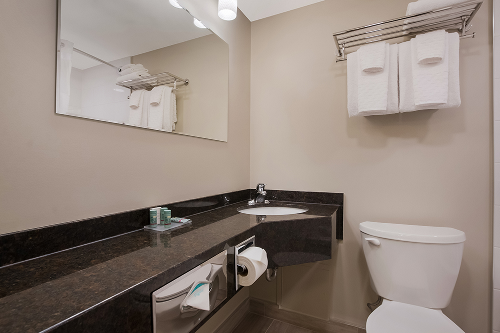 Best Western suite bathroom with toilet and corner sink.