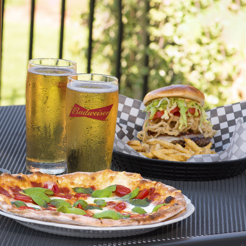 Butlers Bar and Grill outdoor patio; Pizza and Budweiser beer in a cold glass with a burger and fries in the background.